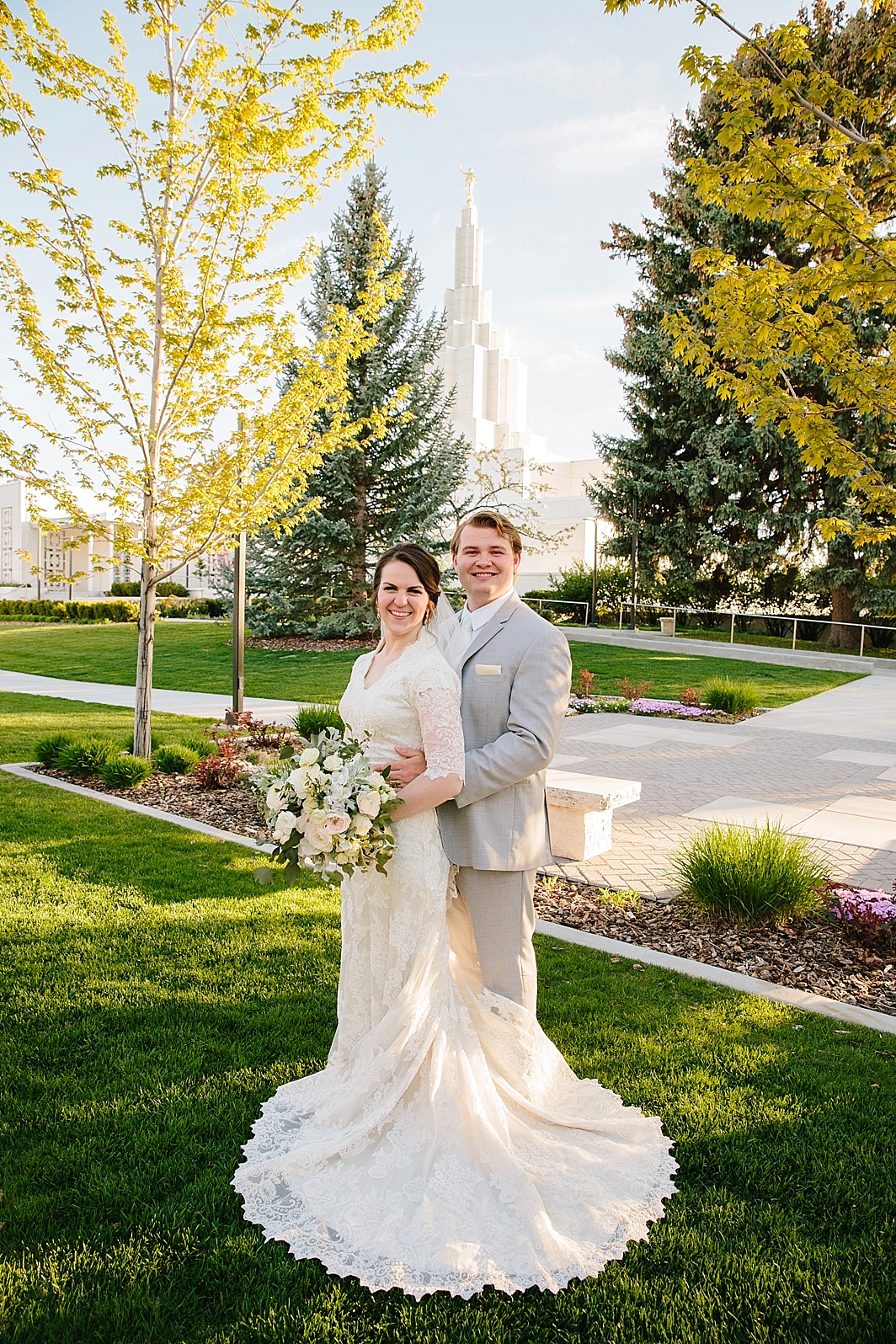 groom embracing bride on Idaho Falls Temple grounds