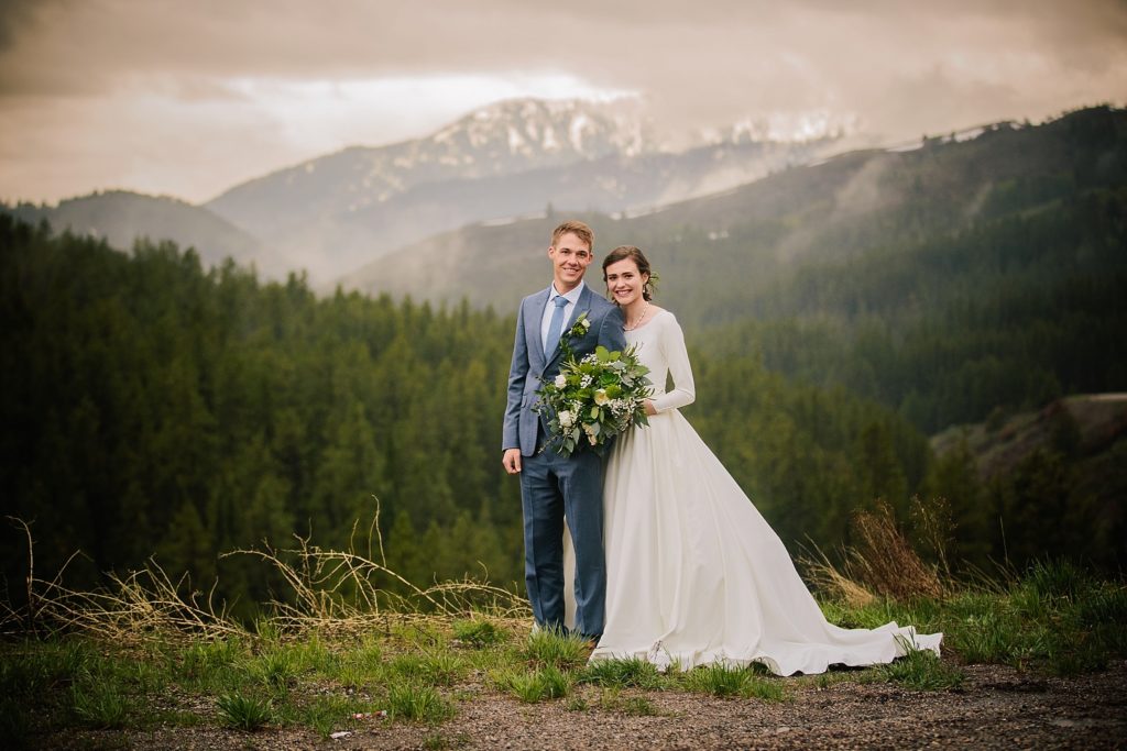 bride and groom standing on top of mountain during outdoor bridals