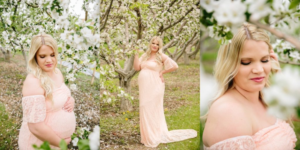 woman standing in apple blossoms during maternity pictures