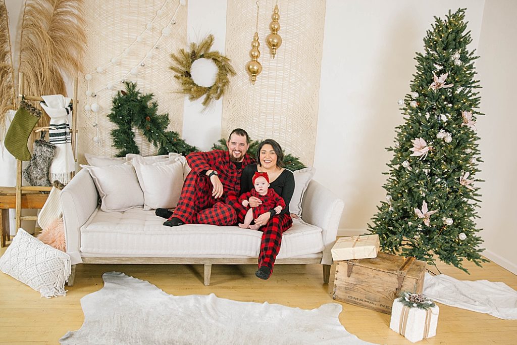 young family sitting on couch wearing matching pajamas during pocatello christmas photography
