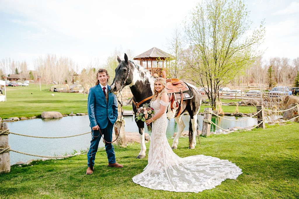 bride and groom with a horse next to a lake in Jackson Hole