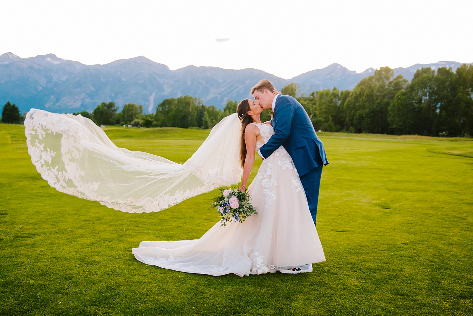 Bride and groom kissing during outdoor wedding at top Jackson Hole wedding venue