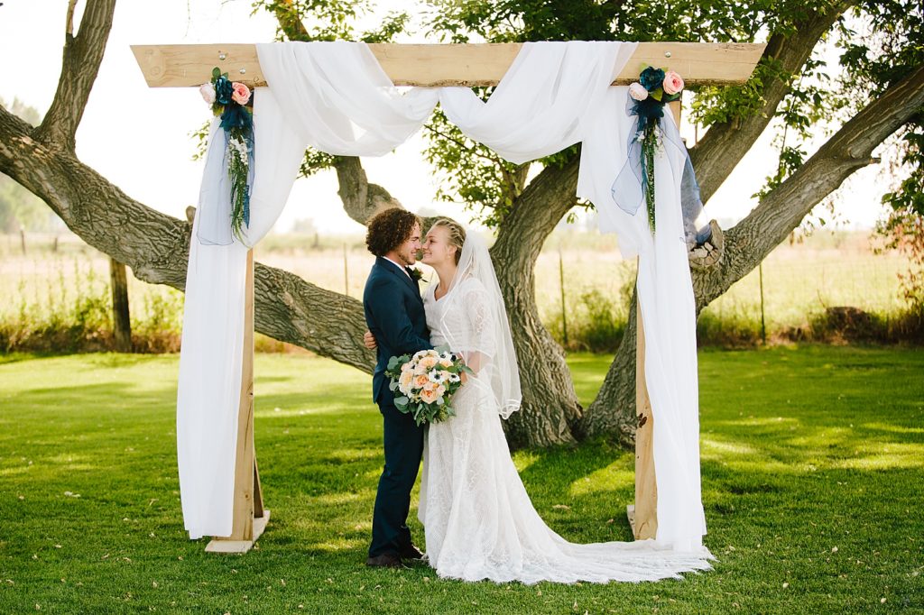 Jackson Hole wedding photographer captures bride and groom kissing under wedding alter
