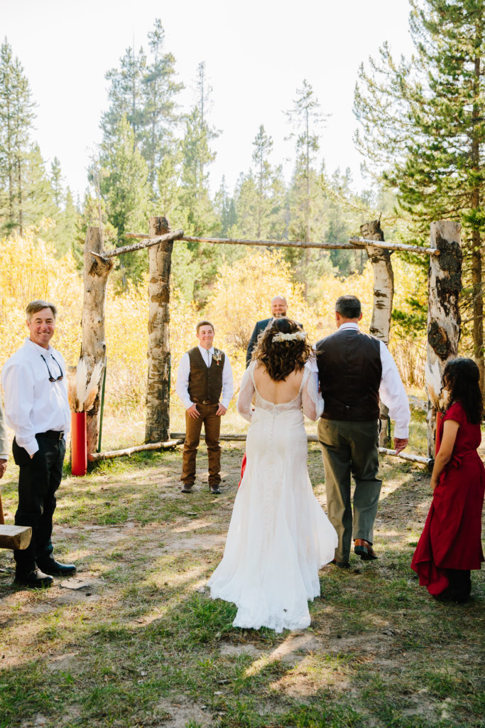 bride being walked down aisle by father at eagle ridge ranch wedding