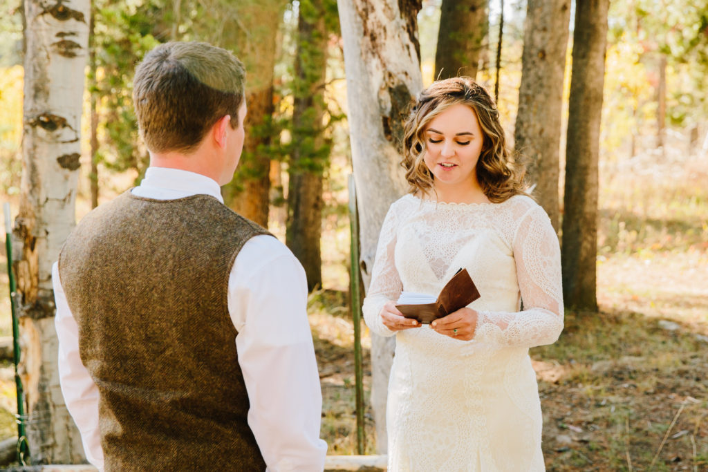 bride reading vows to groom during outdoor rustic wedding ceremony