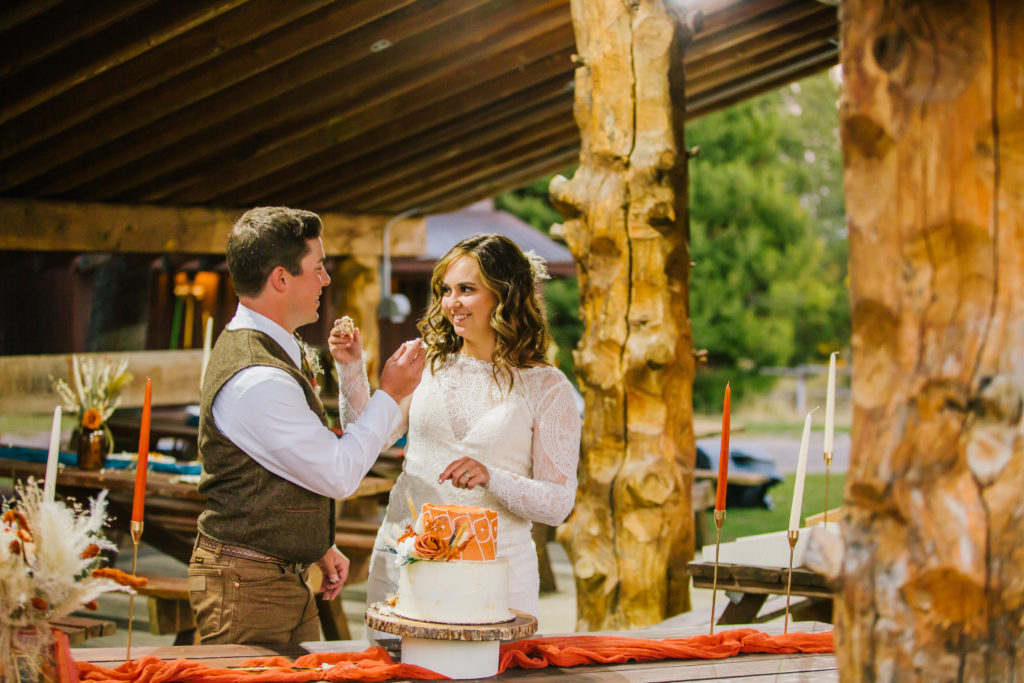 bride and groom eating cake as husband and wife at eagle ridge ranch wedding
