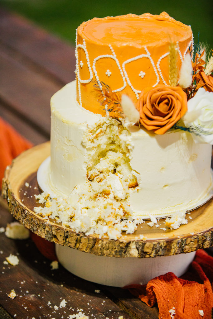 cream and orange fall wedding cake with slice taken out