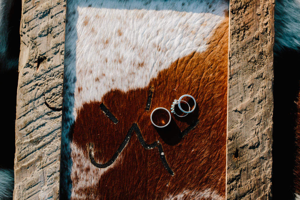 cow hide rug with wedding rings laid on top