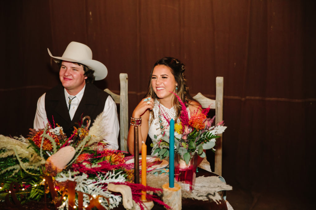 bride and groom sitting at sweethearts table