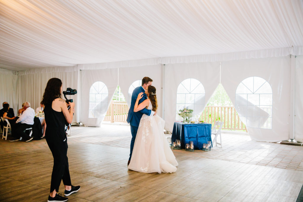 bride and groom dancing inside tent with windows