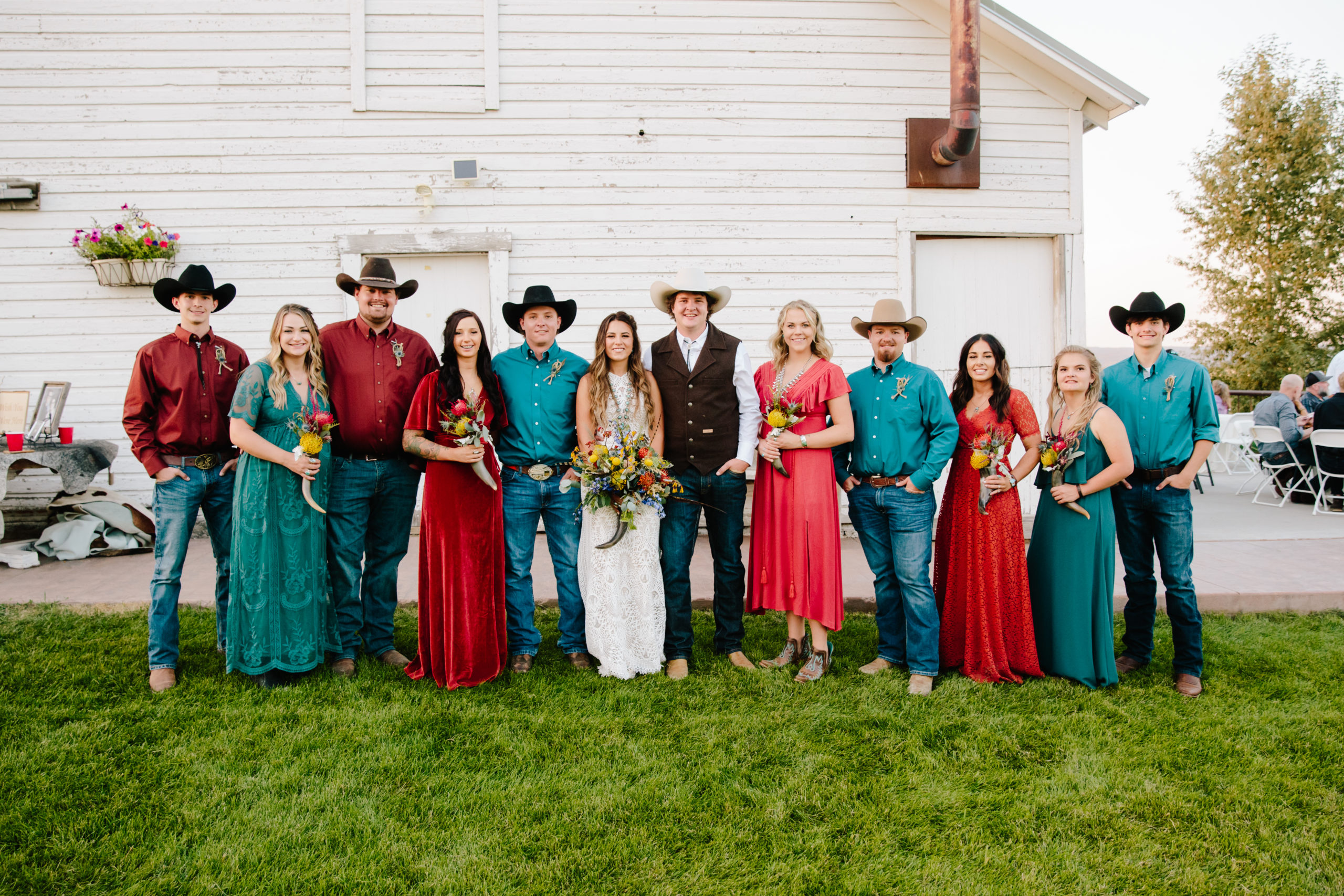 country wedding bridal party stand together outside of a barn for an outdoor wedding 