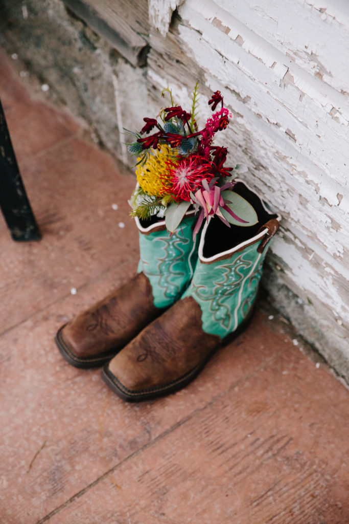 brides florals resting on her teal boots for her Jackson Hole wedding day