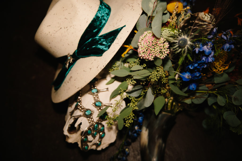 detail shot of wedding florals with a summer garden hat on a chair