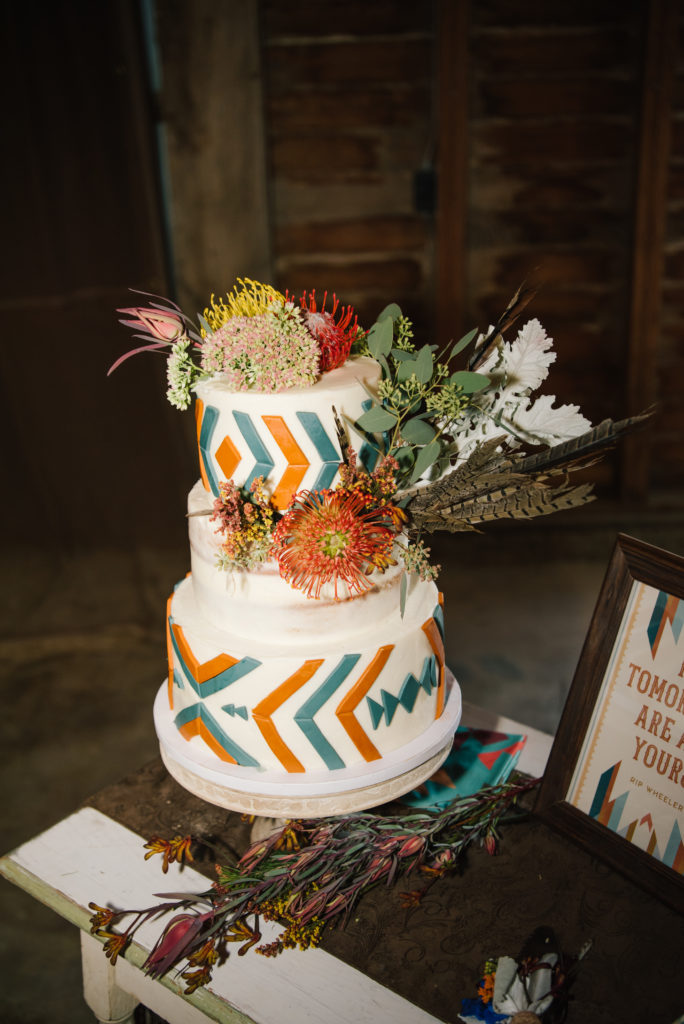 rustic boho two tier wedding cake with florals on the top