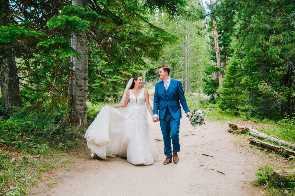 bride and groom walking through Jackson Hole forest during spring Jackson Hole bridals