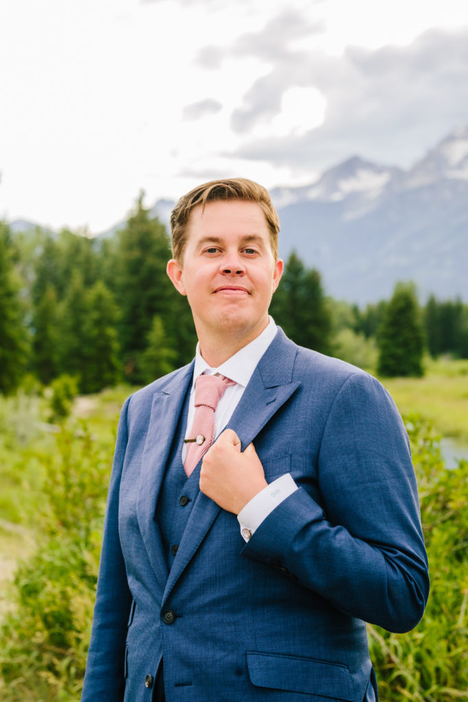 groom holding coat during spring jackson hole bridals