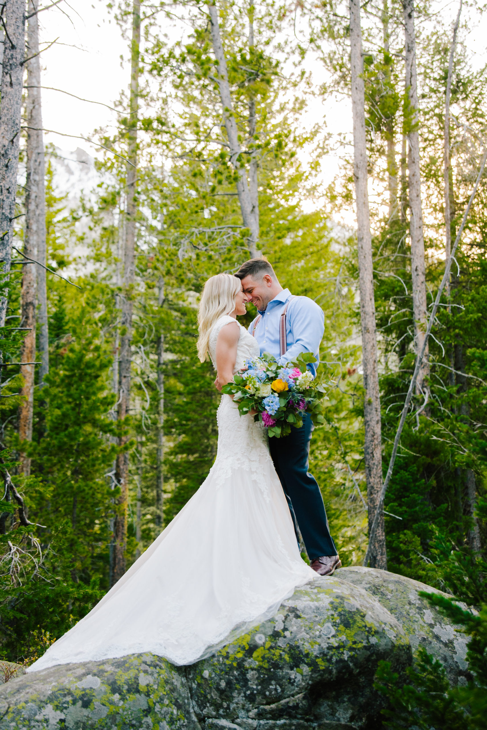 bride and groom standing on rock kissing after jackson hole vow renewal