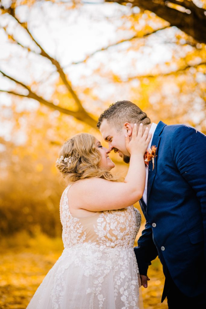 Jackson Hole wedding photographer captures bride holding her grooms face and smiling and they lean into each other