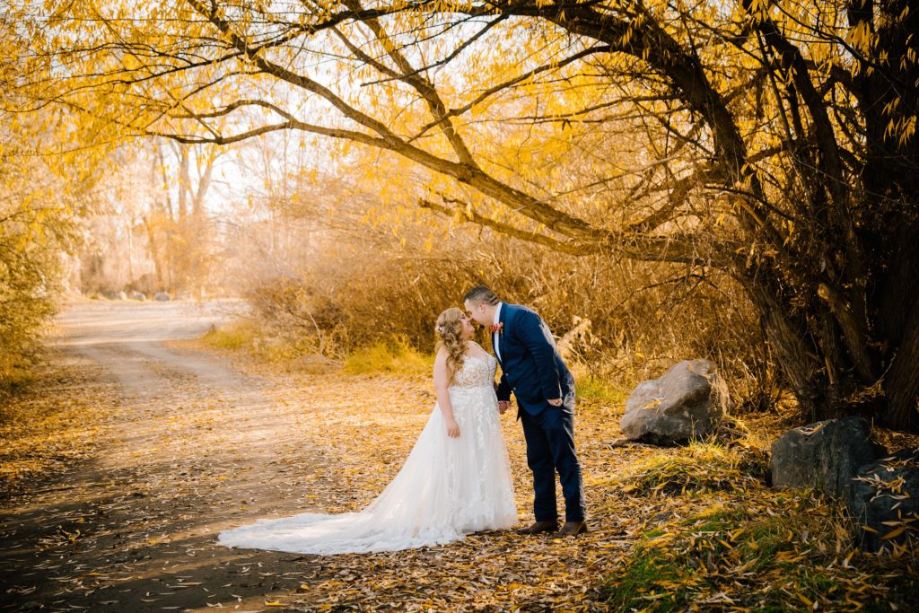 Jackson Hole wedding photographer captures bride and groom kissing in forest during fall bridals portraits