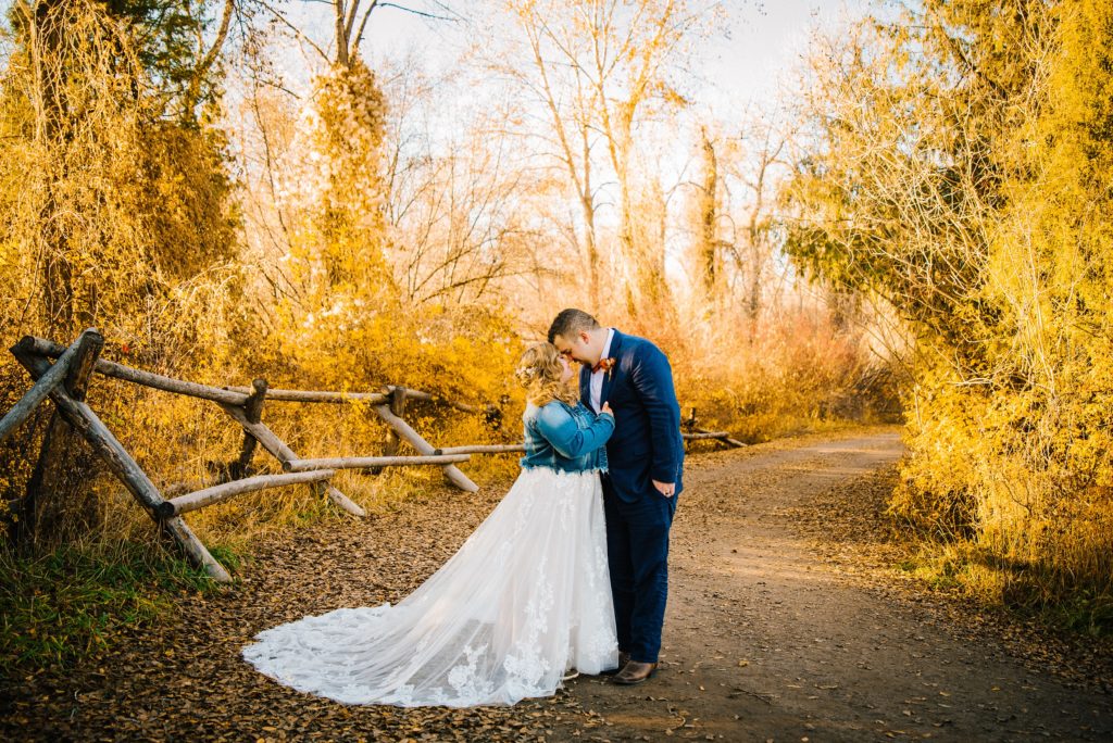 Jackson Hole wedding photographer captures bride and groom kissing in beautiful fall trees
