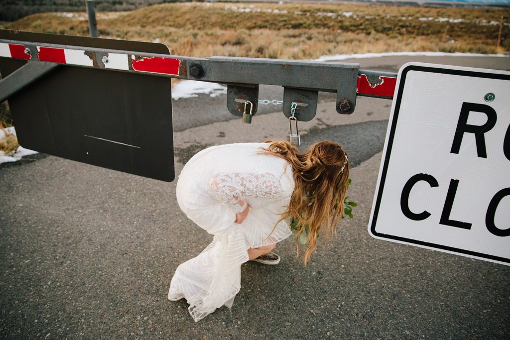 Jackson Hole wedding photographer captures bride kneeling under sign