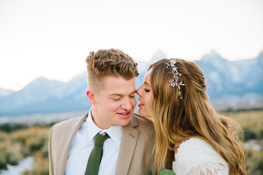 outdoor bridals with Pocatello bride and groom whispering to each other as they stand in a field 