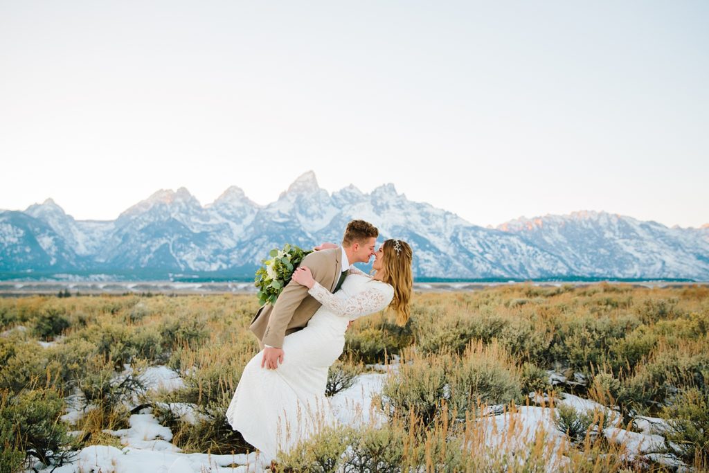 Jackson Hole wedding photographer captures bride and groom kissing in front of Grand Teton mountains