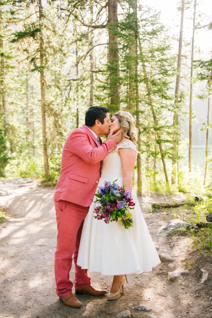 Jackson Hole wedding photographer captures bride and groom Kissing in the forest wedding