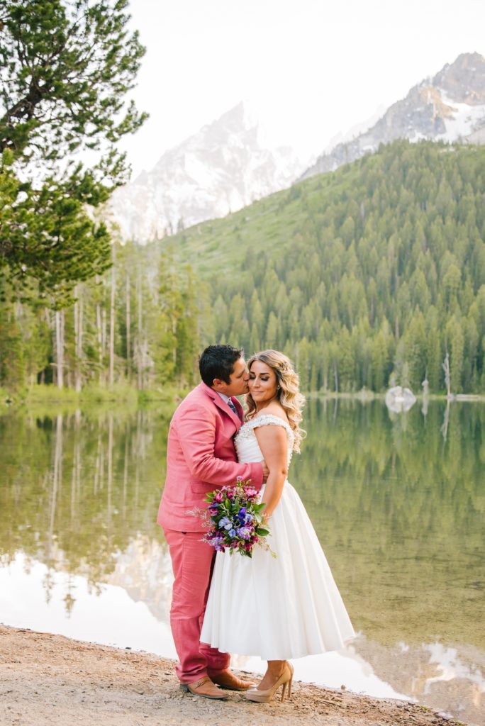 Jackson Hole wedding photographer captures couple kissing in front of Leigh Lake