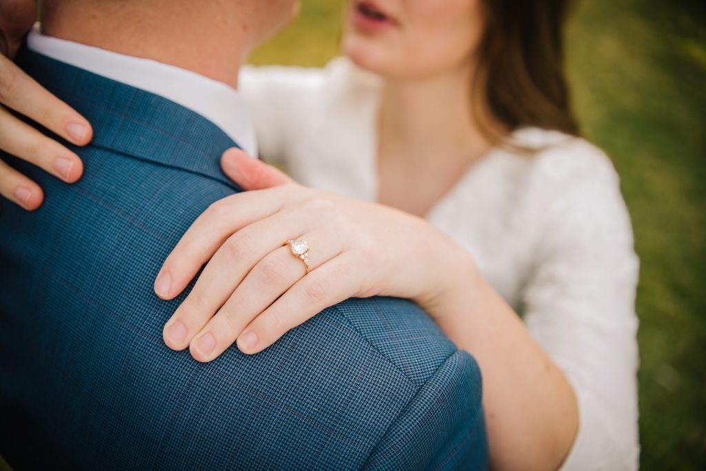 Close up of engagement ring on groom’s suit
