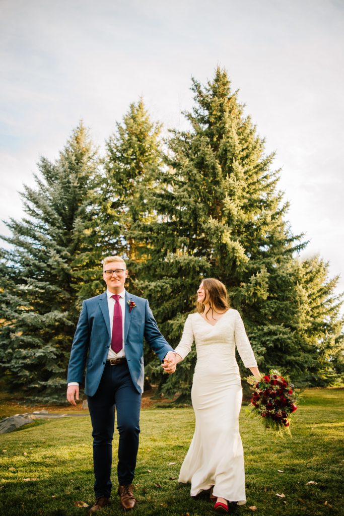 Jackson Hole wedding photographer captures bride and groom walking through trees