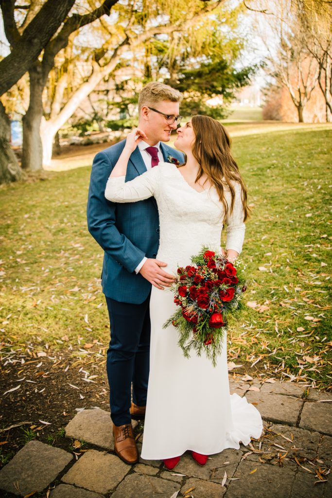 Jackson Hole wedding photographer captures bride holding groom's cheek during portraits