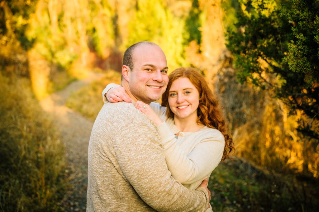 Jackson Hole wedding photographer captures man and woman embracing in front of fall colored trees