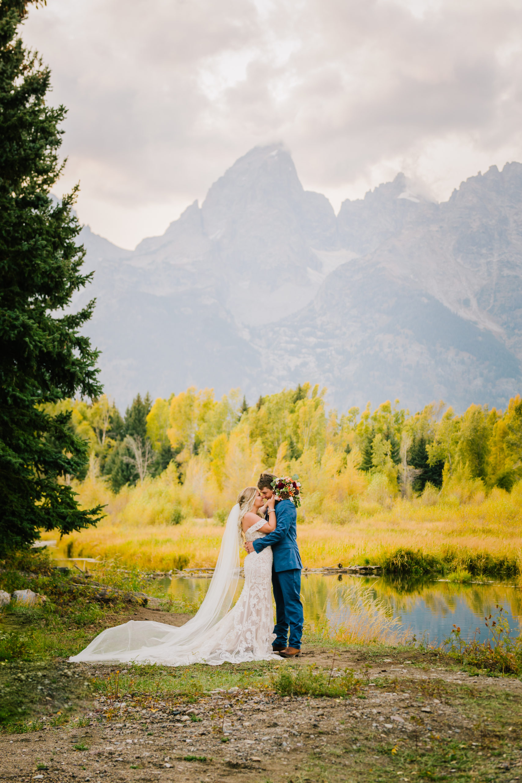 jackson hole wedding in the fal with groom kissing brides forehead with the Tetons in the distance 