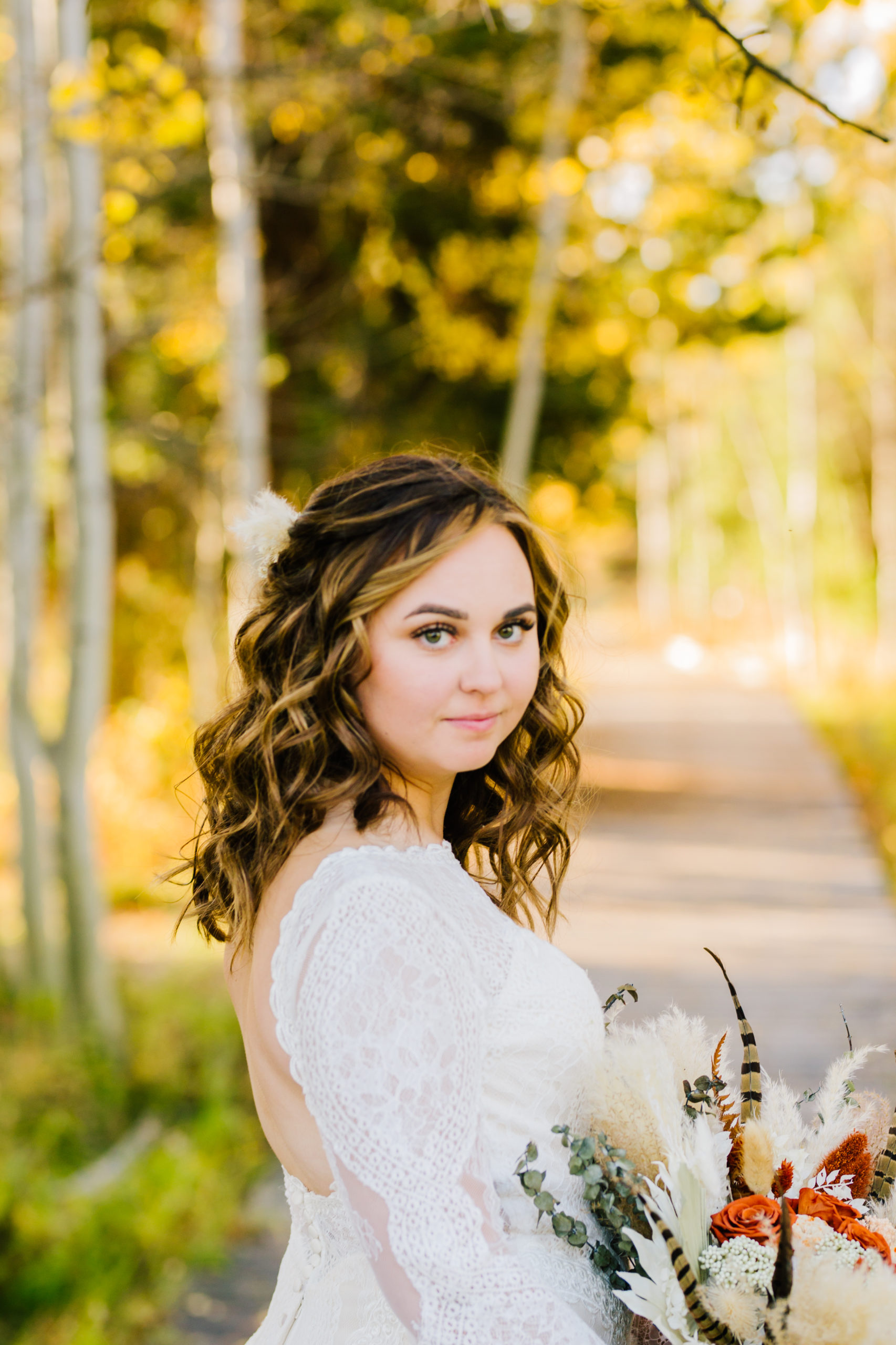bride looking over her shoulder to the camera for her fall wedding in Yellowstone