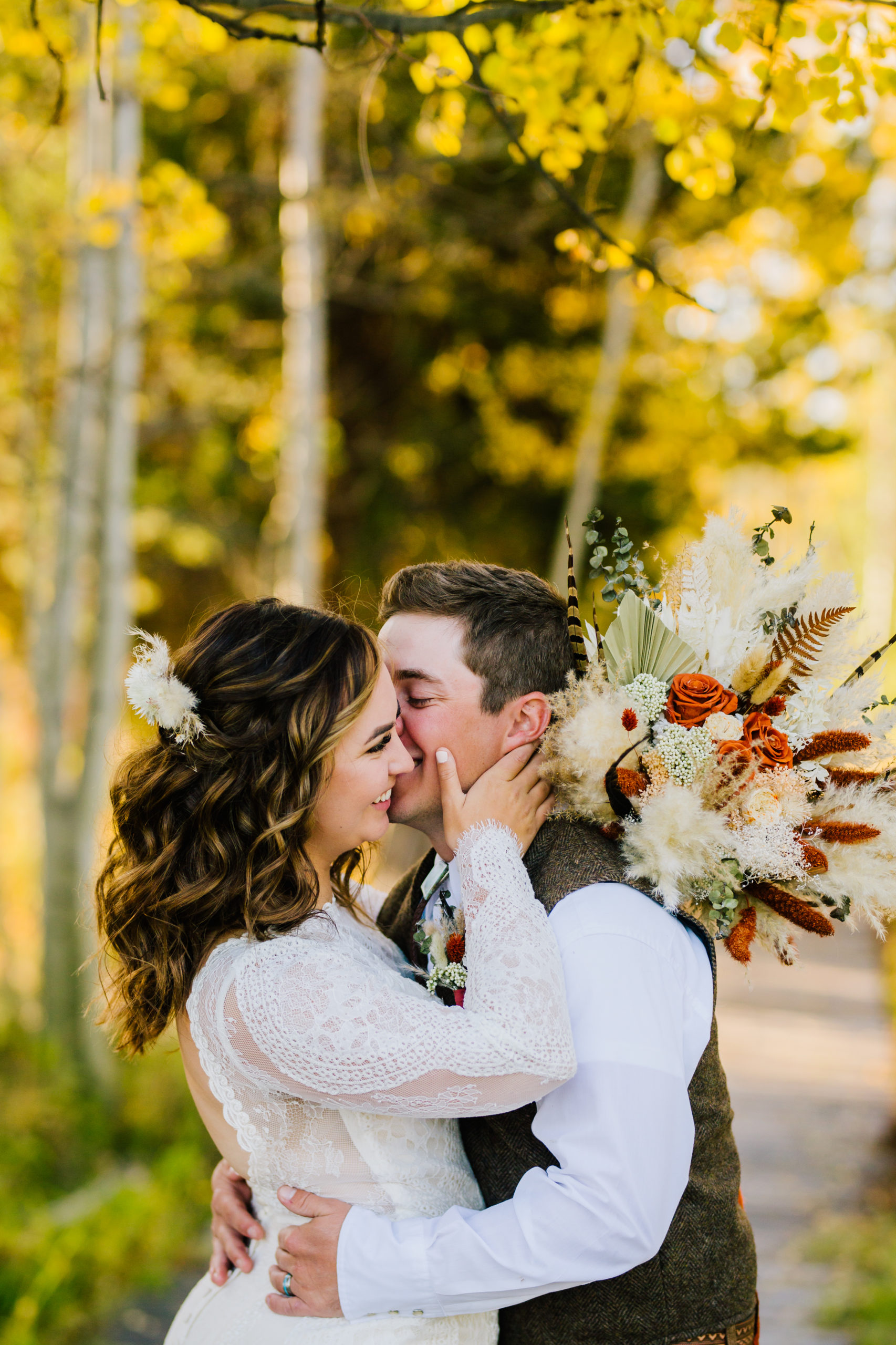 bride and groom outside for their fall Yellowstone wedding day with groom kissing brides face