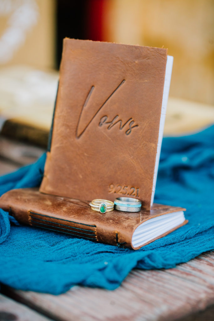 Jackson Hole wedding photographer captures wedding details with leather vow book and wedding bands