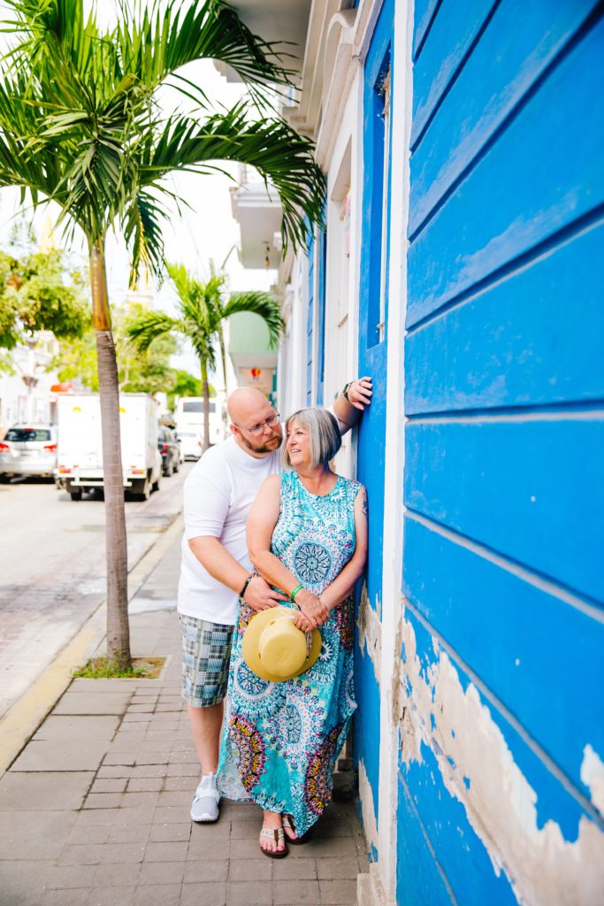 Jackson Hole wedding photographer captures man and woman standing against brightly colored mazatlan building