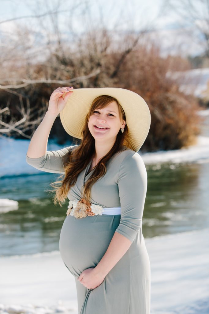 Jackson Hole wedding photographer captures woman standing by river wearing hat