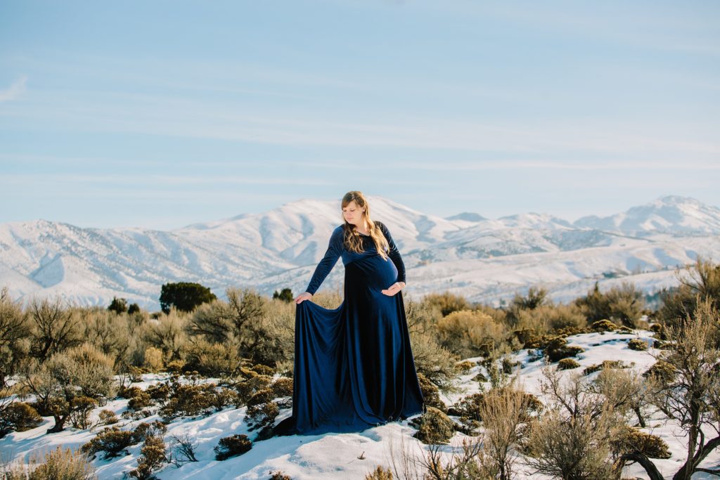 Jackson Hole wedding photographer captures woman wearing navy dress during maternity pictures