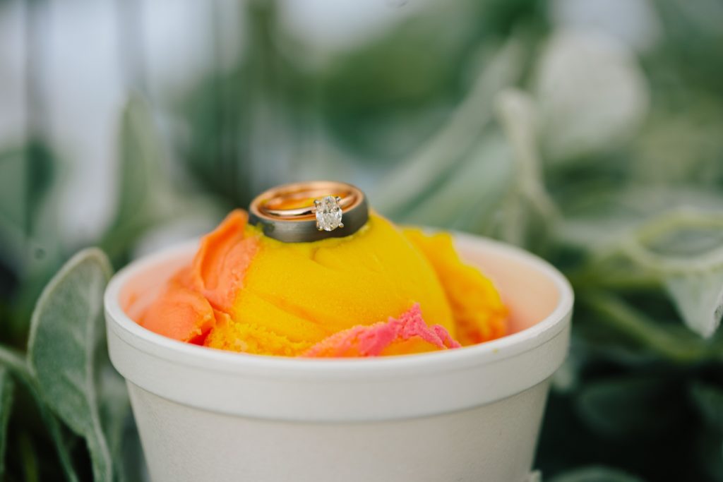 Jackson Hole wedding photographer captures Ice cream from jungle retreat thats pink and yellow with wedding ring on top