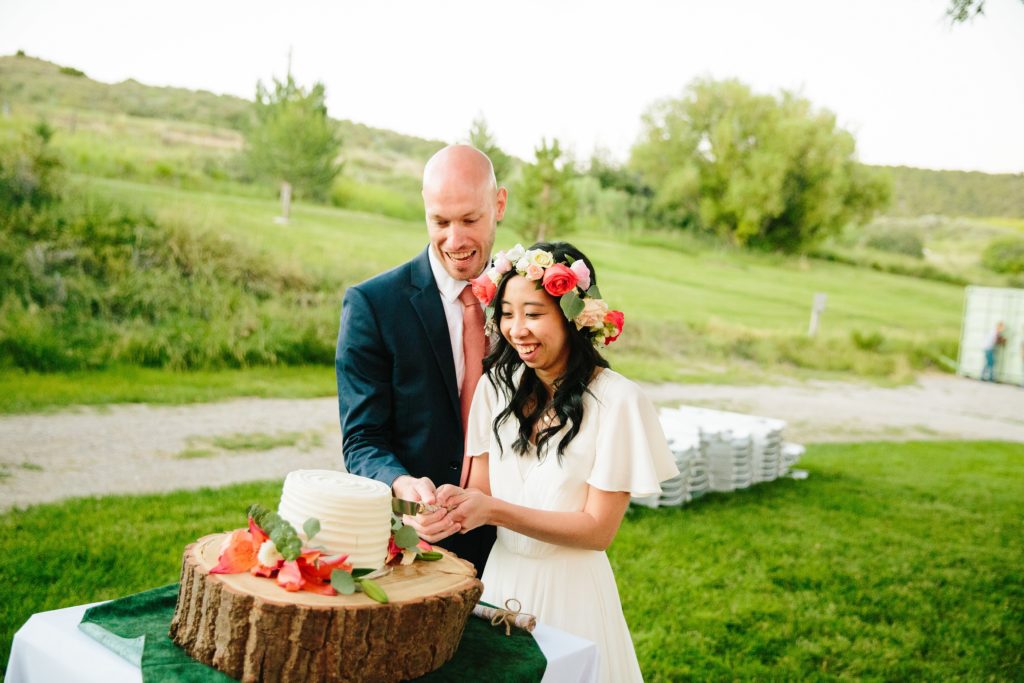 Jackson Hole wedding photographer captures Bride and groom cutting their cake
