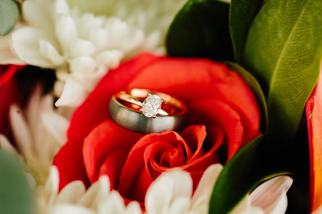 Pocatello wedding with red and white flowers, detail shot of the wedding ring in a red rose