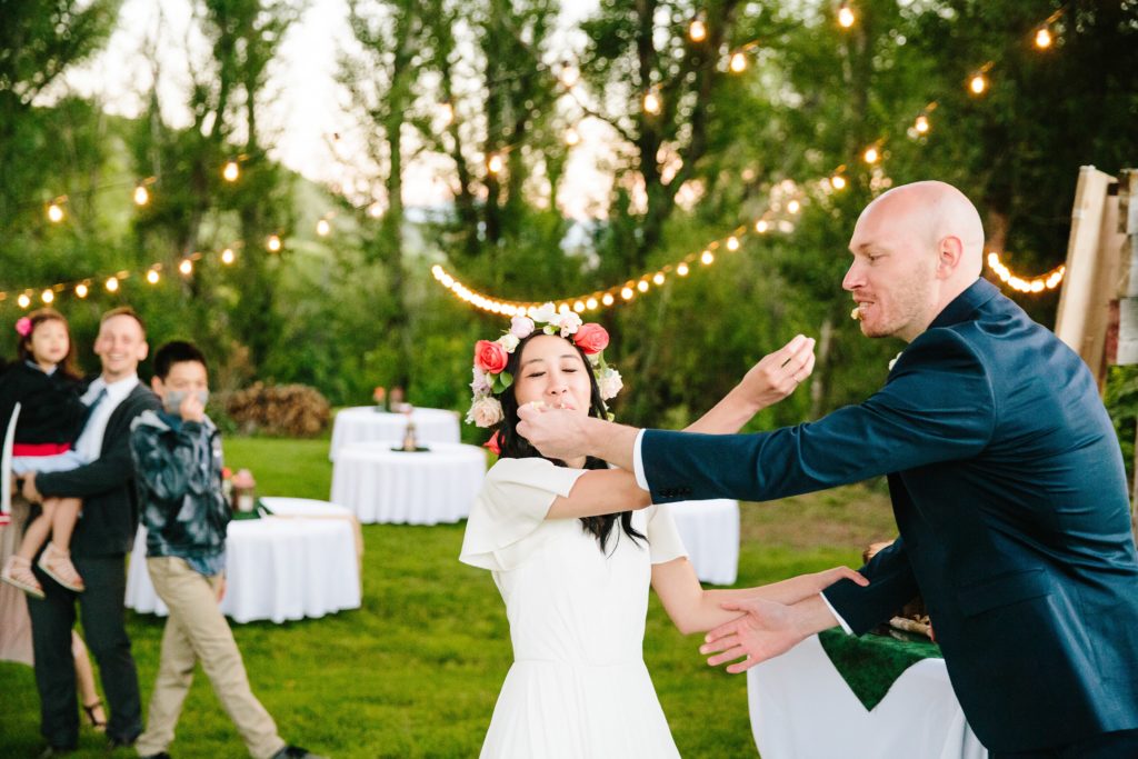 Jackson Hole wedding photographer captures Bride and groom smashing cake in faces of each other