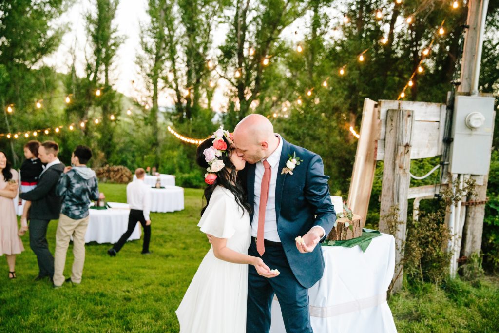 Jackson Hole wedding photographer captures Bride and groom kissing after cake fight