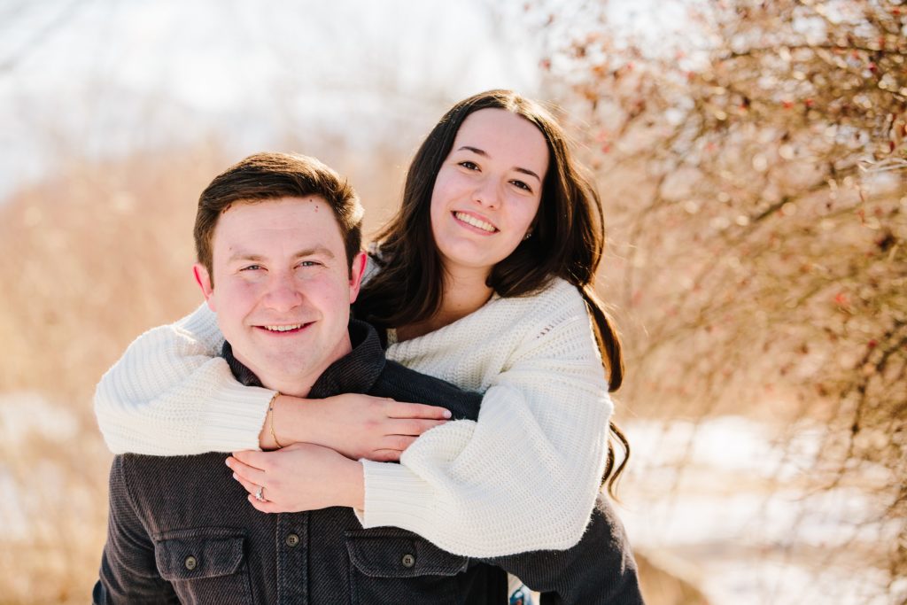 Jackson Hole wedding photographer captures woman on man's back during winter engagements