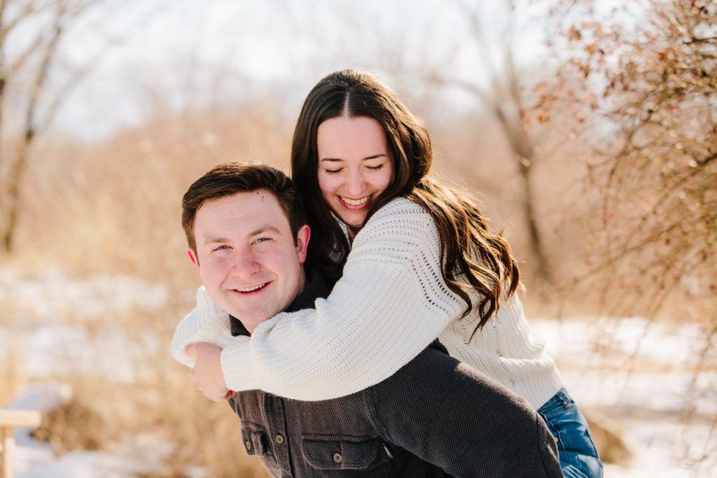 Jackson Hole wedding photographer captures Piggy back ride in snowy pocatello engagements