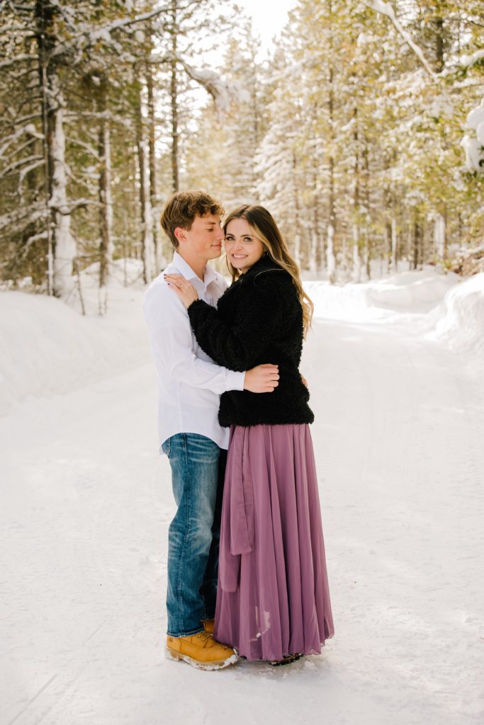 Jackson Hole wedding photographer captures couple embracing during snowy engagements