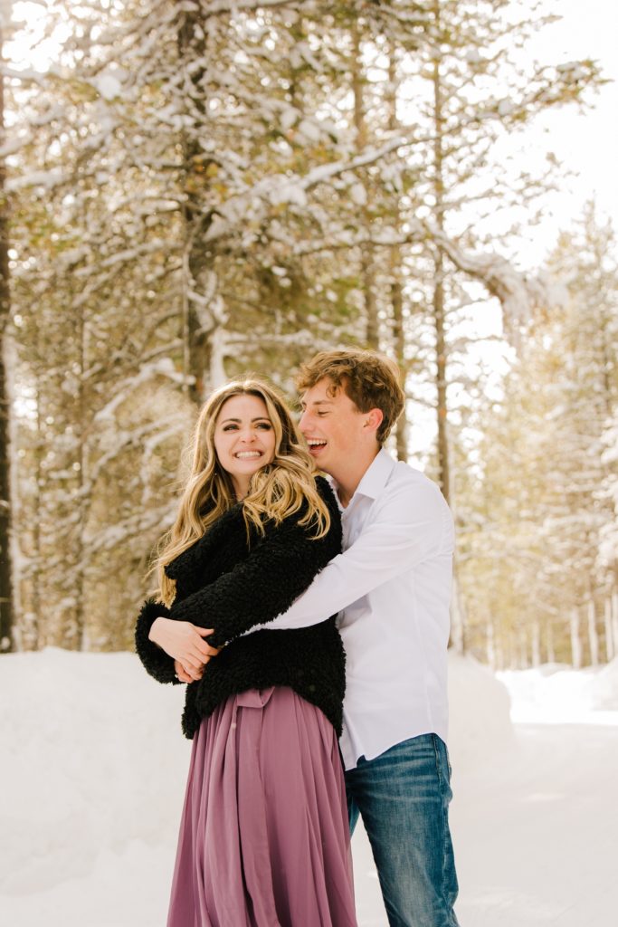 Jackson Hole wedding photographer captures couple hugging during snowy engagements