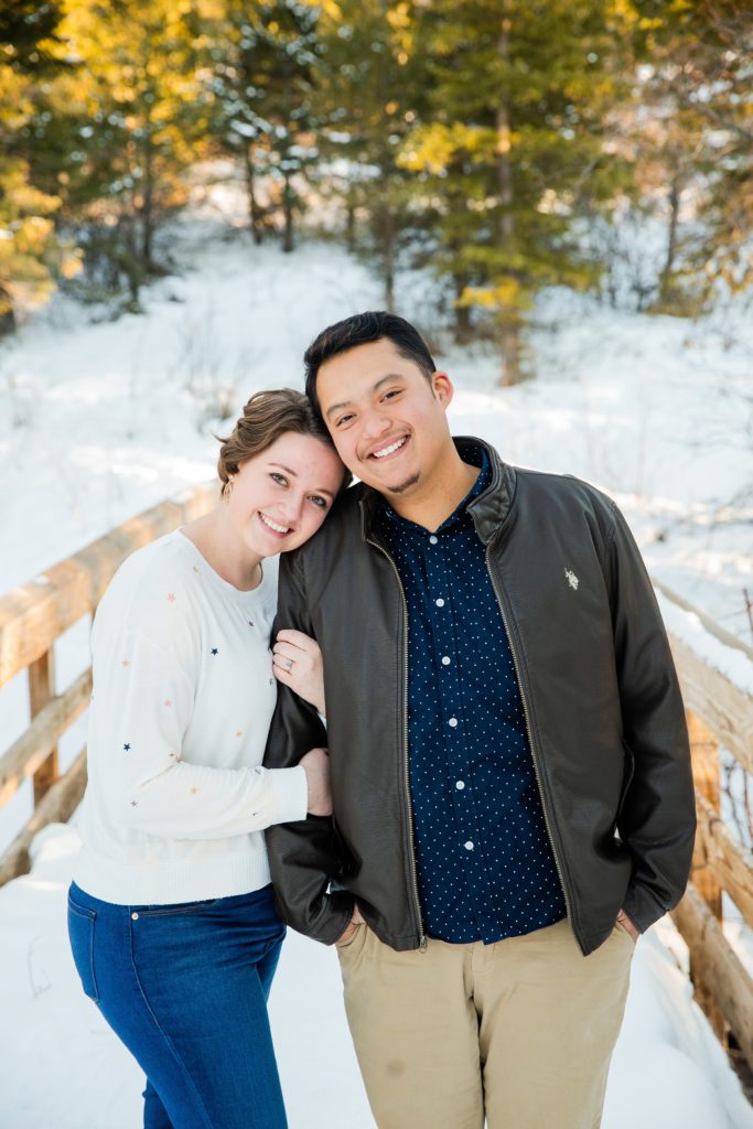 Jackson Hole wedding photographer captures woman and man embracing during snowy winter engagements
